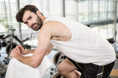 Serious man on exercise bike looking at the camera