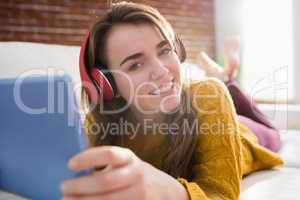 Smiling pretty woman listening music with her tablet