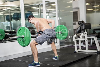 Shirtless man lifting barbell