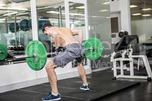 Shirtless man lifting barbell