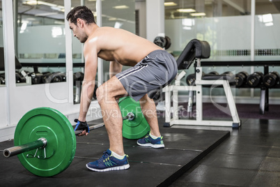 Shirtless man lifting barbell