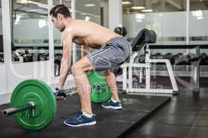 Shirtless man lifting barbell