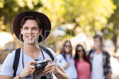 Hip man with digital camera smiling