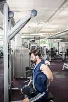 Focused man using weights machine for arms