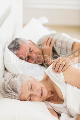 Senior couple sleeping in bed