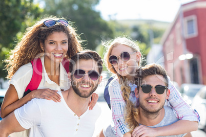 Hip men giving piggy back to their girlfriends