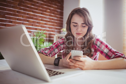 Young hipster businesswoman using her phone