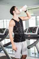 handsome man on treadmill drinking water