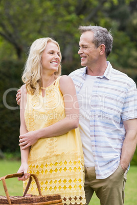 Happy couple holding picnic basket