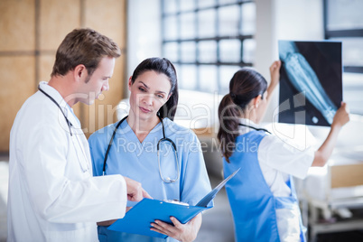 Medical team discussing the report on clipboard