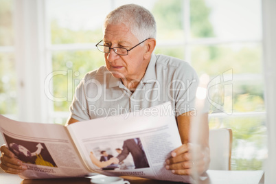 Focused senior man reading newspaper