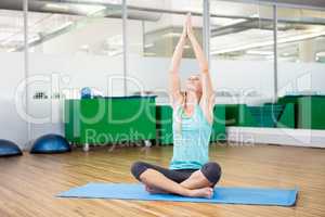 Fit woman doing yoga on mat