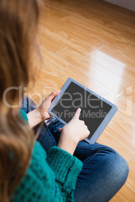 Woman sitting on the floor while using her tablet