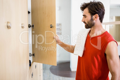 Smiling man opening locker