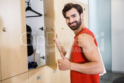 Smiling man opening locker