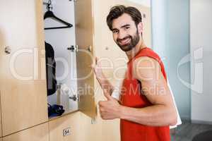 Smiling man opening locker