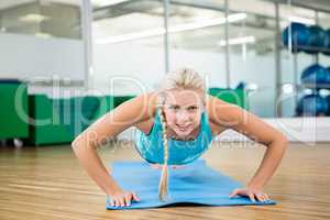 Fit blonde doing push up on mat