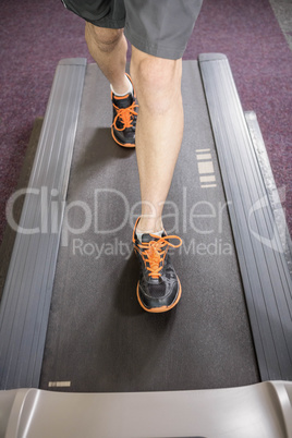 Lower section of man running on treadmill