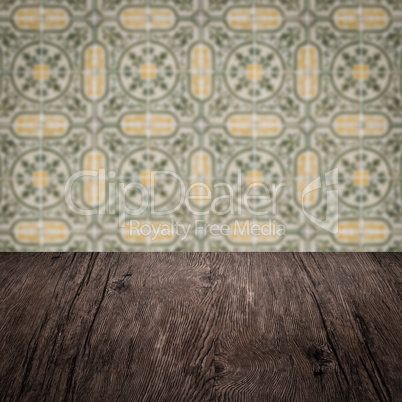 Wood table top and blur vintage ceramic tile pattern wall