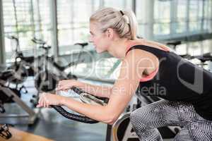 Smiling woman using exercise bike