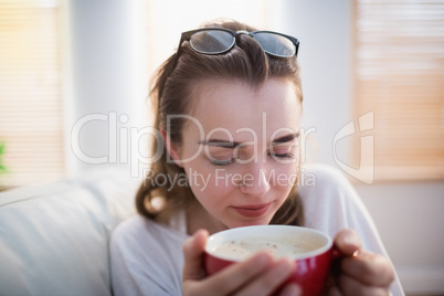 Pretty woman relaxing on couch with coffee