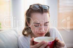 Pretty woman relaxing on couch with coffee