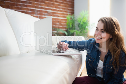 Pretty woman sitting on the floor using laptop