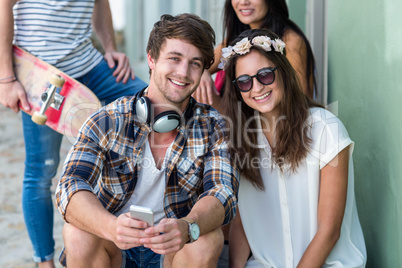 Hip friends sitting on steps looking at the camera