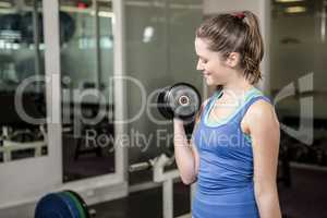 Fit woman lifting dumbbell