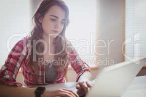 Serious hipster businesswoman working on computer