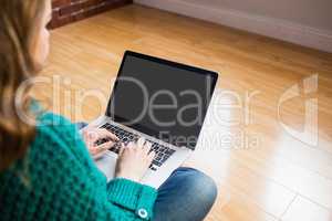 Woman sitting on the floor while using her laptop