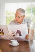 Focused senior man reading newspaper