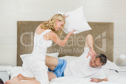 Cute couple playing pillow fight