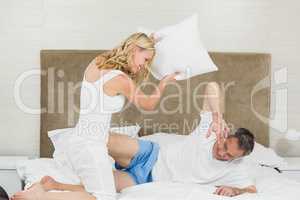 Cute couple playing pillow fight