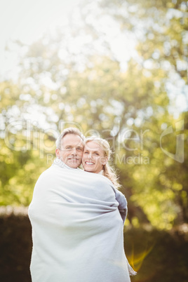 Cute couple hugging with a blanket around