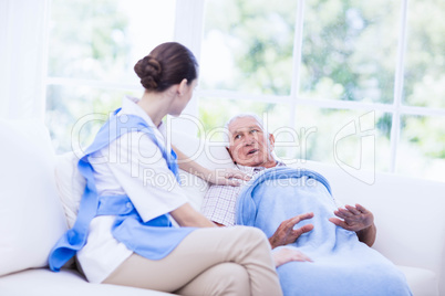 Nurse taking care of sick elderly patient