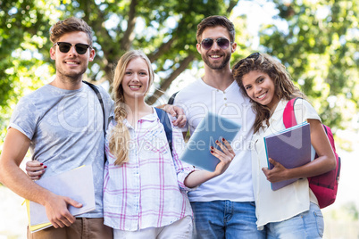 Hip friends holding tablet and notebooks