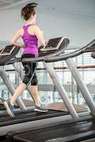 Fit brunette running on treadmill