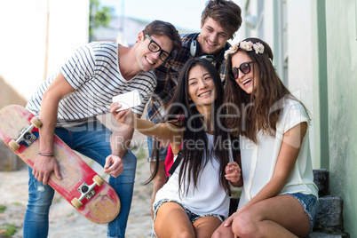 Hip friends taking selfie sitting on steps