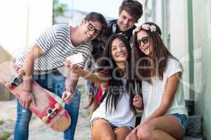 Hip friends taking selfie sitting on steps