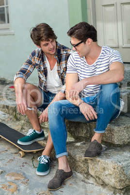 Hip men sitting on steps