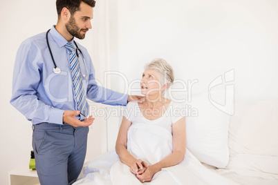 Handsome home nurse talking to elderly woman