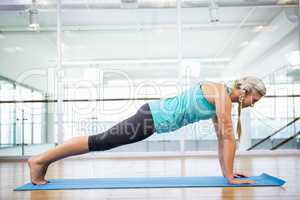 Fit blonde doing exercise on mat