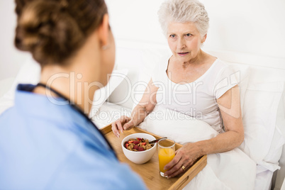 Nurse taking care of suffering senior patient