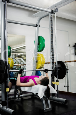 Fit woman lifting the barbell bench press