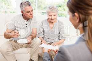 Businesswoman showing documents to senior couple