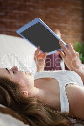 Pretty woman relaxing on couch with tablet