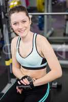 Smiling woman sitting on barbell bench