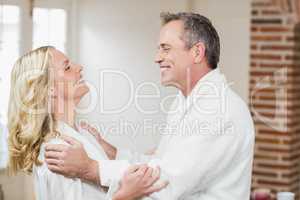 Cute couple cuddling in bathrobes