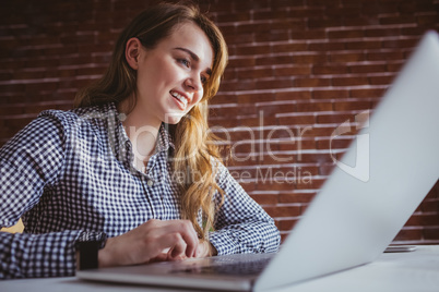 Smiling young hipster businesswoman using her computer